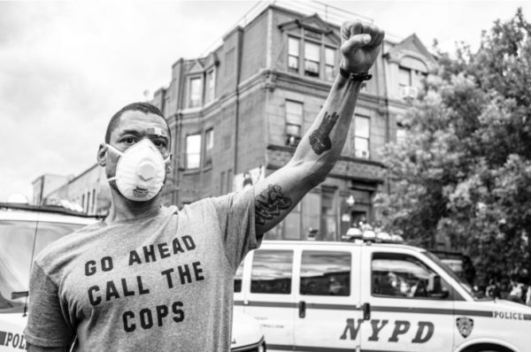 PHOTOGRAPH BY RUDDY ROYE, NATIONAL GEOGRAPHIC Kyle Errison raises a fist in solidarity with marchers who chanted "Justice for George Floyd." Errison says, "I have been harassed by NYPD and in a way I understand this struggle personally.”