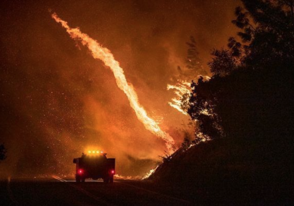Photo: Karl Mondon/San Jose Mercury News. Caption: An emergency vehicle traveling up Highway 162 Oroville, Calif., is dwarfed by a fire whirl generated by the Bear Fire raging around Lake Oroville, Wednesday, Sept. 9, 2020.