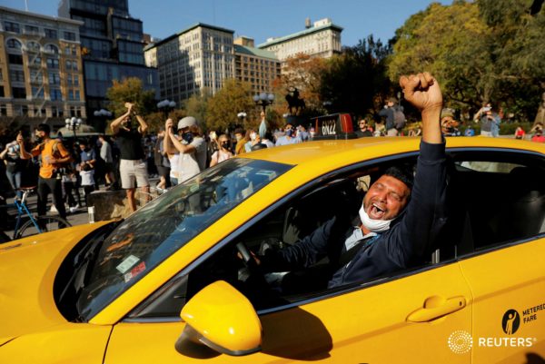 A cab driver raises his fist as people celebrate media announcing that Democratic U.S. presidential nominee Joe Biden has won the 2020 U.S. presidential election on Union Square in Manhattan. Photo by Andrew Kelly/Reuters