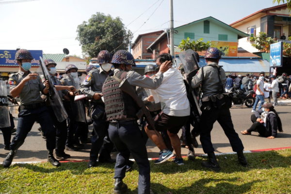 A demonstrator is detained by police officers