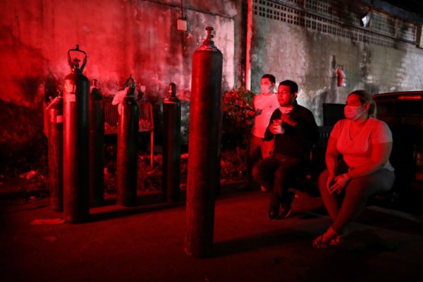 Relatives of patients hospitalized or receiving healthcare at home, mostly suffering from COVID-19, gather to buy oxygen and fill cylinders at a private company in Manaus, Brazil January 15, 2021. REUTERS/Bruno Kelly