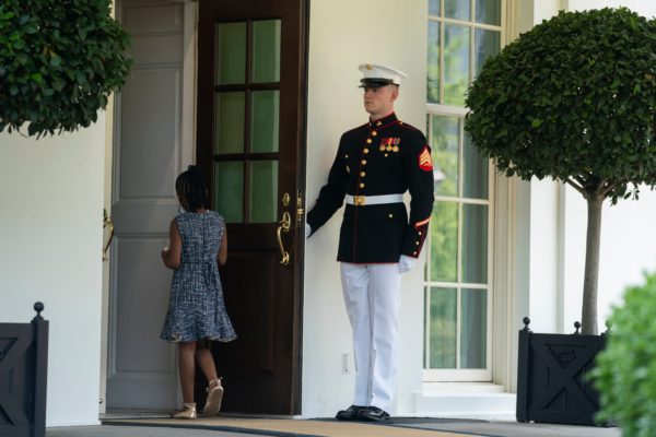 A Marine holds the door as Gianna Floyd, the daughter of George Floyd, walks into the White House.