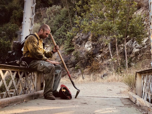 A firefighter sits outside Big Sur at the beginning of wildfire season in 2021.