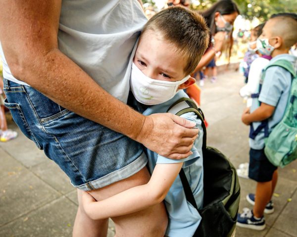 Photo: Al Seib/LA Times. Kindergartner August Russell clinging to his mother outside Jackson Elementary in Altadena, California, on August 12, 2021, as students return to campus after more than a year of pandemic shutdowns and virtual learning.